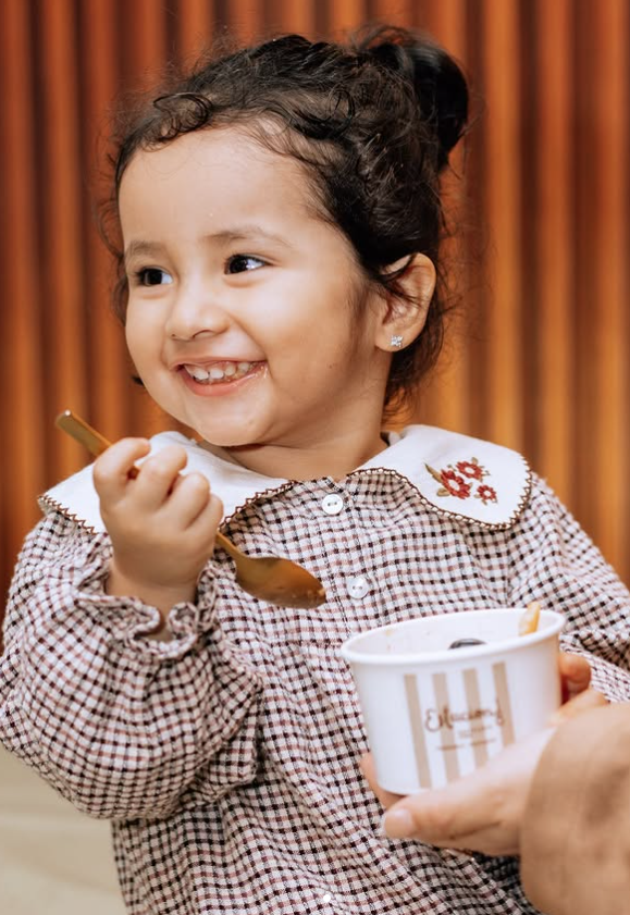 Una pequeña clienta disfrutando un postre de Estación 18 Bistró